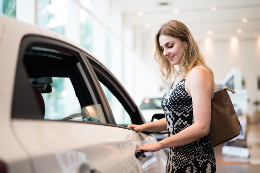 Woman looking at a car in a showroom