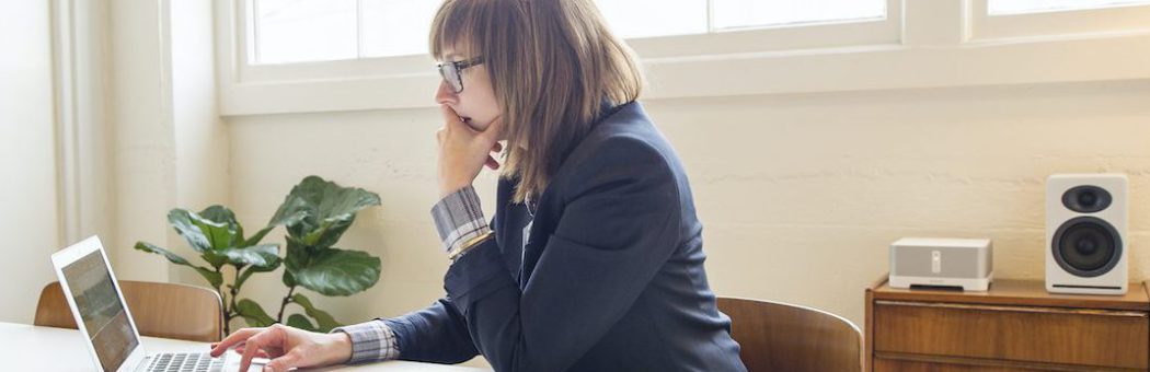 Businesswoman using laptop at desk in office