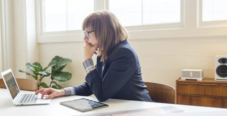 Businesswoman using laptop at desk in office