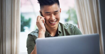 young man talking happily on phone