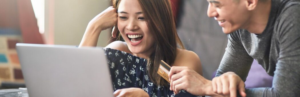 Happy couple shopping online on laptop