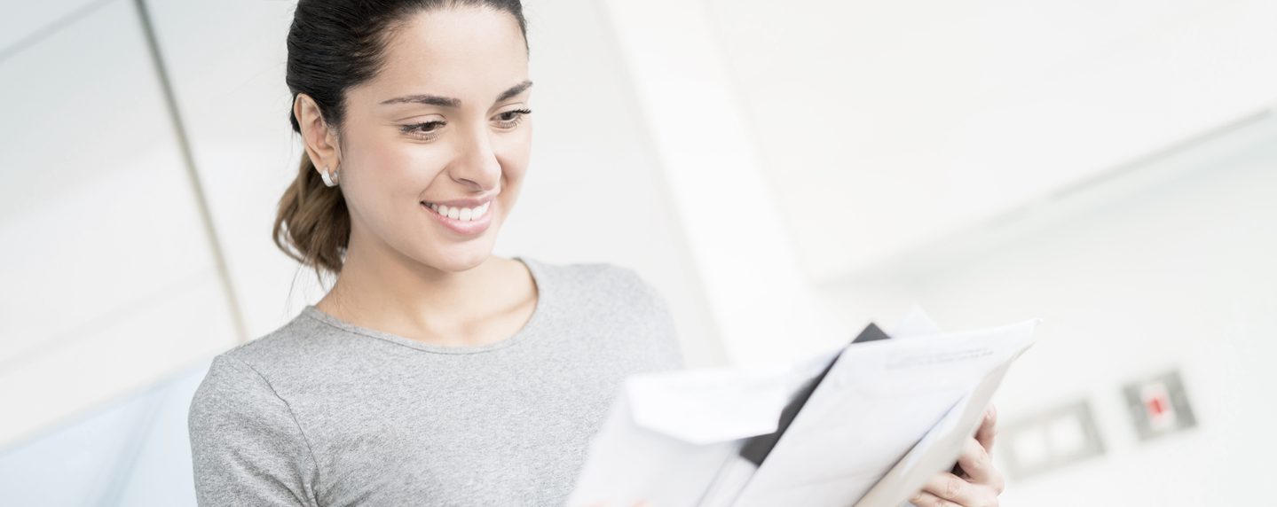 Portrait of a young woman at home getting the mail