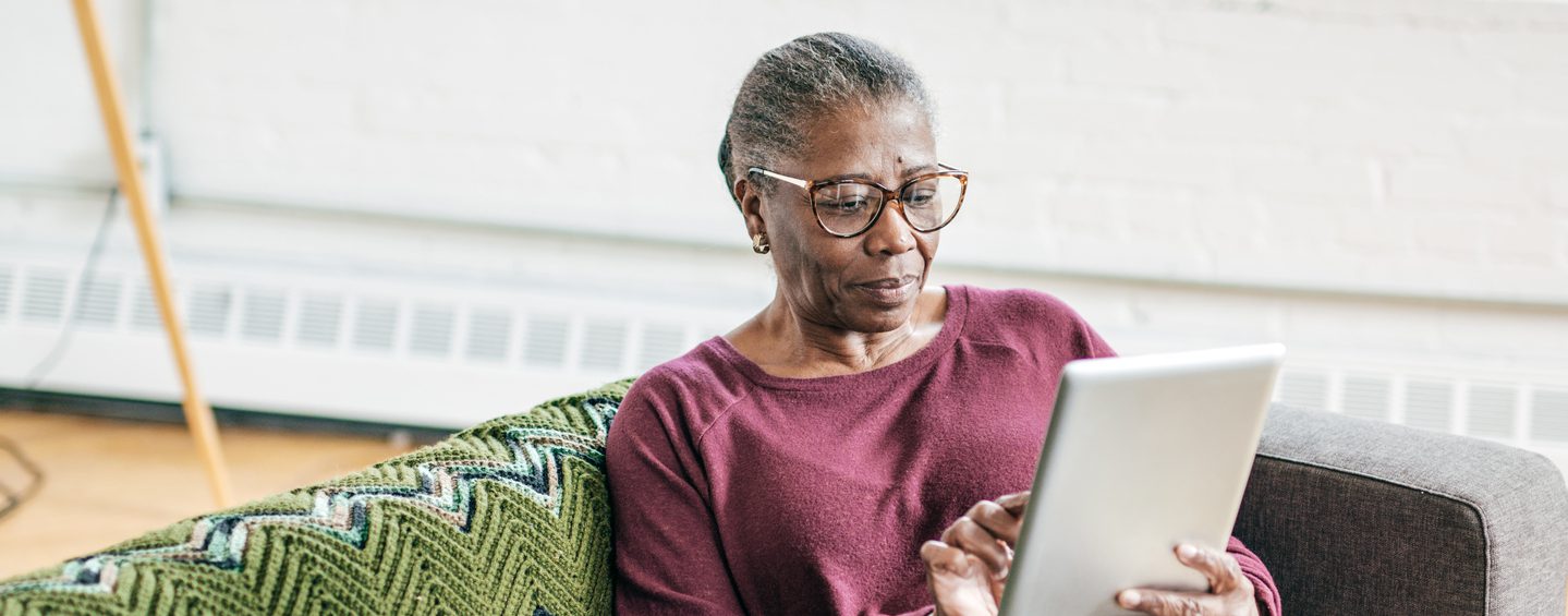 Senior woman relaxing whilst using a tablet