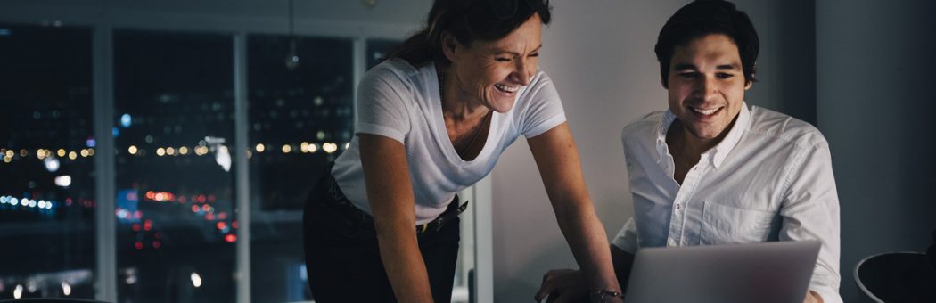 Two people working on a laptop