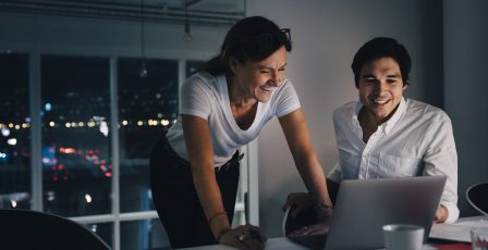 Two people working on a laptop