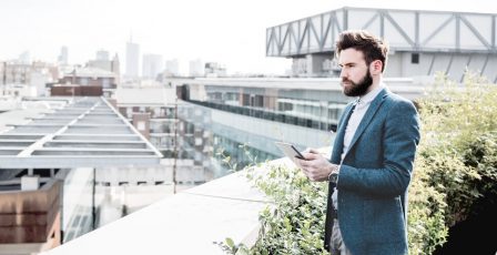 Man on a rooftop looking towards a city