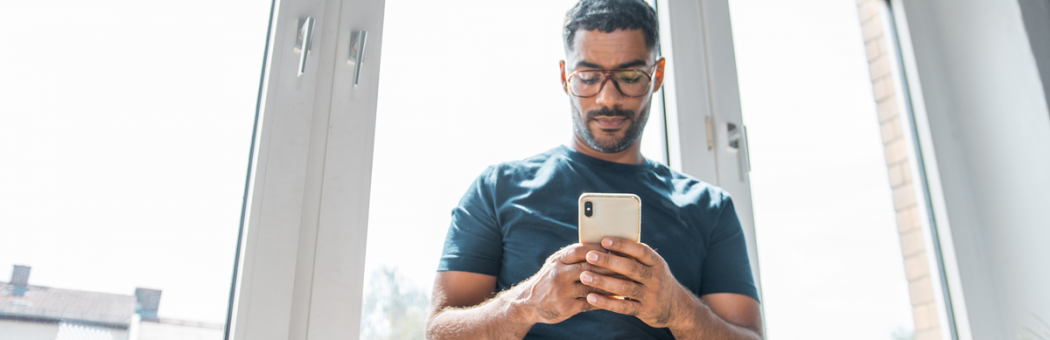 Man sat at a window on phone