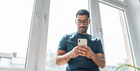 Man sat at a window on phone