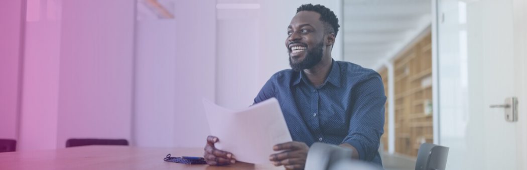 Man smiling while holding reports