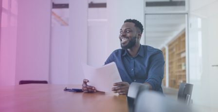 Man smiling while holding reports