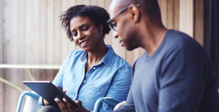 Couple smiling, looking at tablet