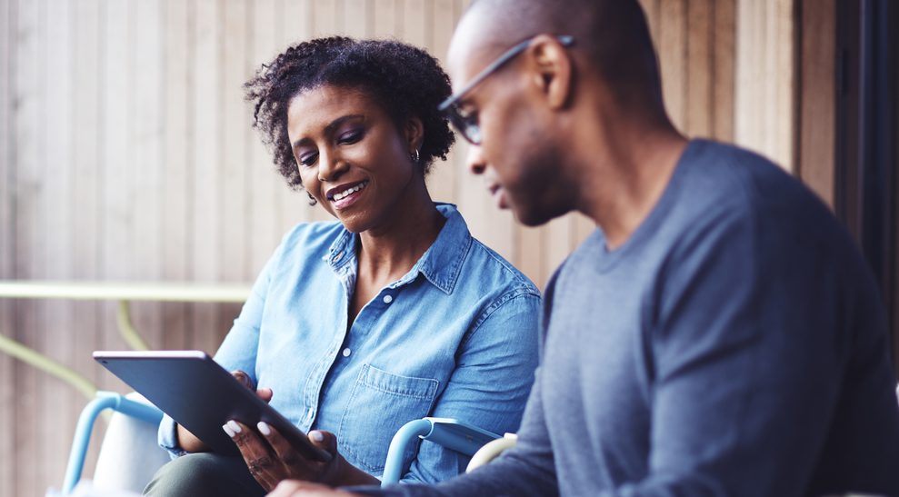 Couple smiling, looking at tablet