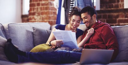 Young couple reading mortgage application papers