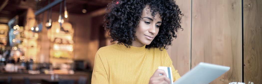 Young woman using a credit card with her tablet