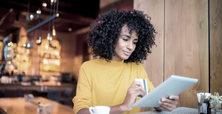 Young woman using a credit card with her tablet