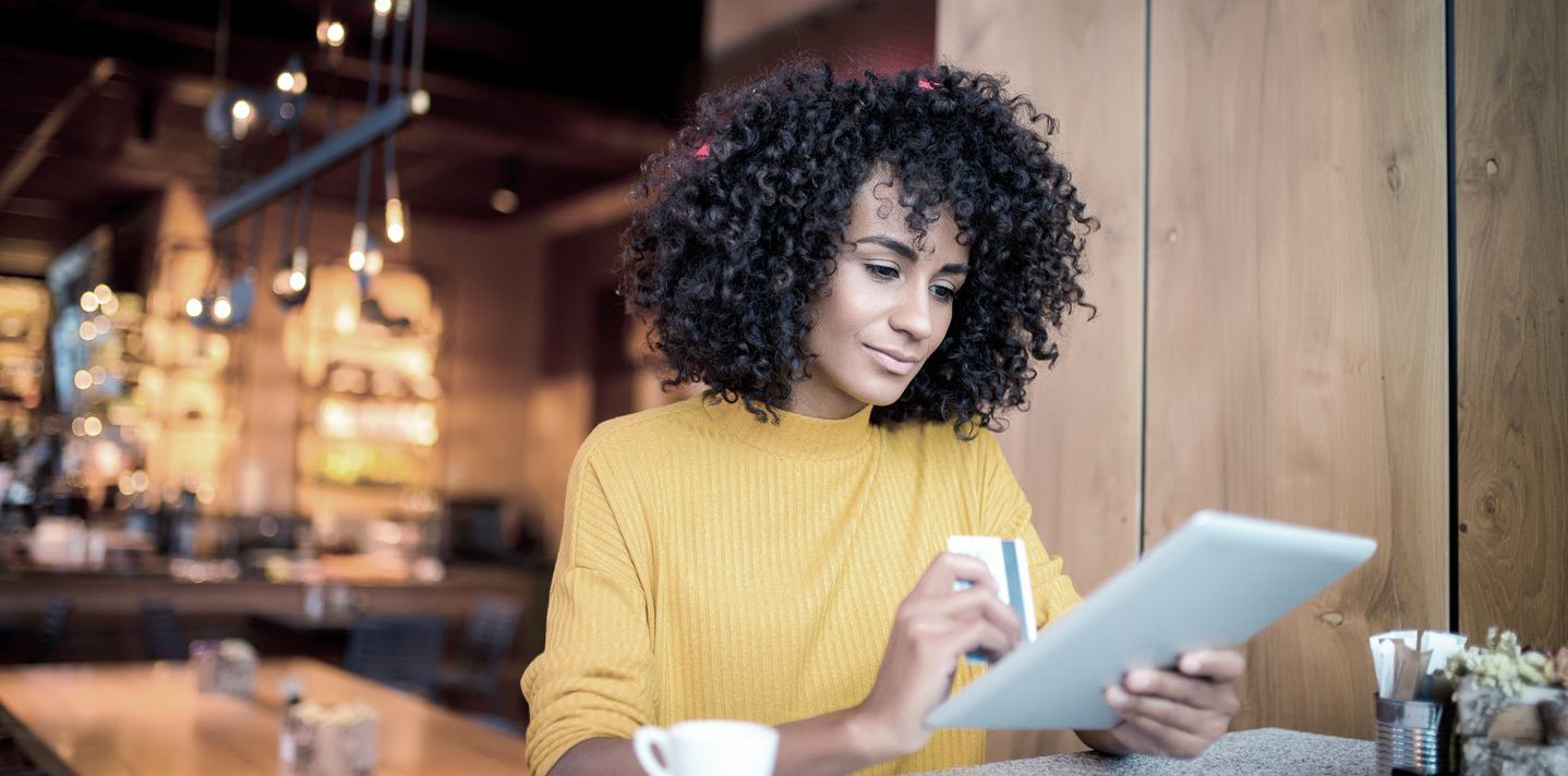 Young woman using a credit card with her tablet