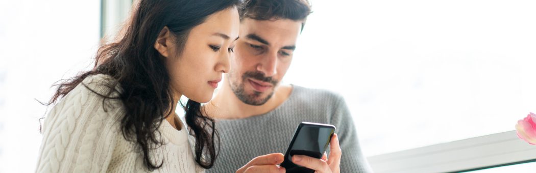 Young couple checking smartphone