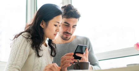 Young couple checking smartphone