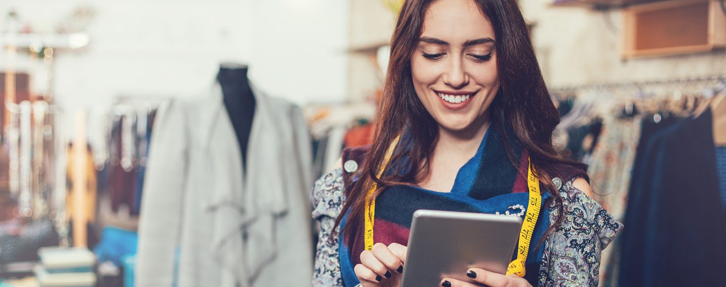 Young female tailor checking her online orders