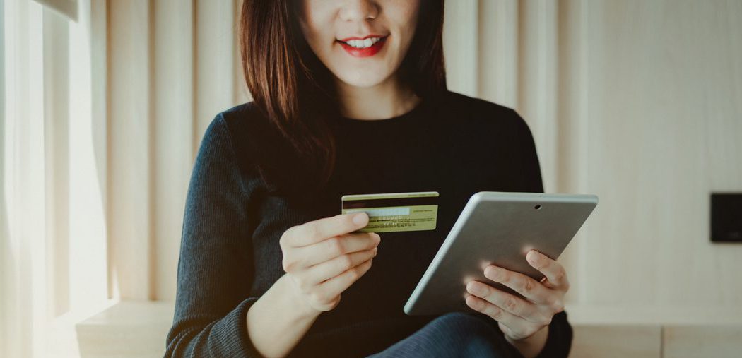 Young woman using a credit online with a tablet