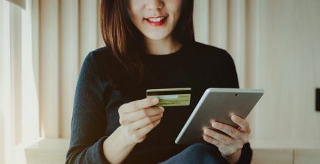 Young woman using a credit online with a tablet