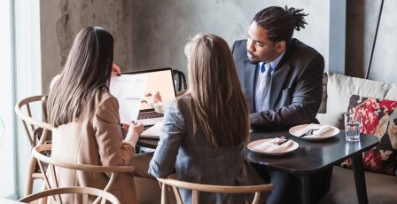 Three people in a job interview sharing documents