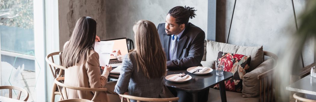 Three people in a job interview sharing documents