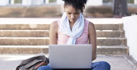Young woman sitting outside using a laptop