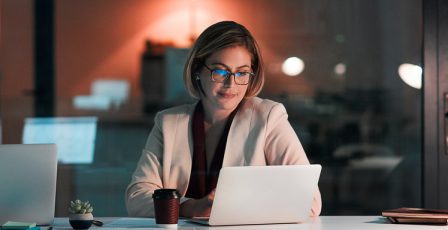 Businesswoman using a laptop at her desk during a late night at work