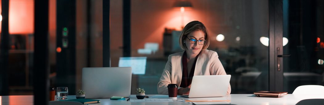 Businesswoman using a laptop at her desk during a late night at work