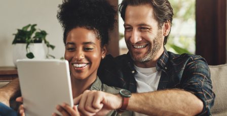 Couple smiling looking at a tablet