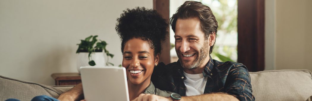 Couple smiling looking at a tablet