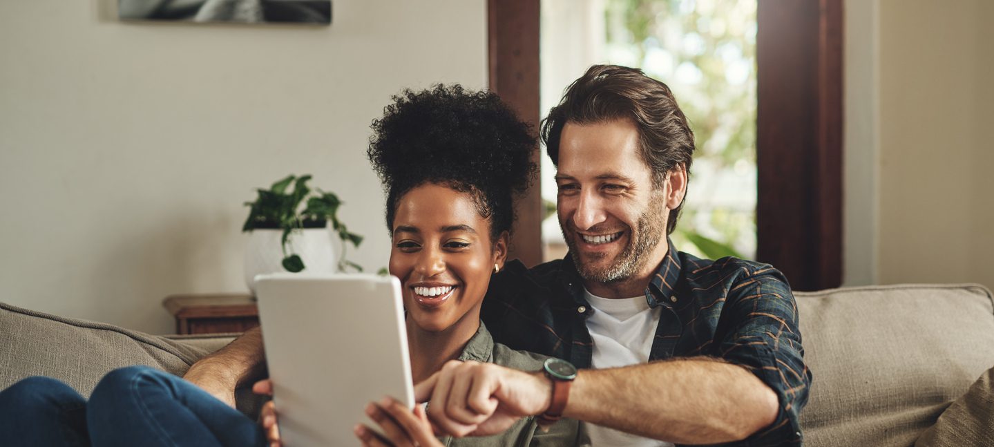 Couple smiling looking at a tablet