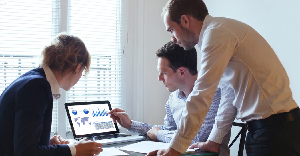 Employees looking at statistics on a computer