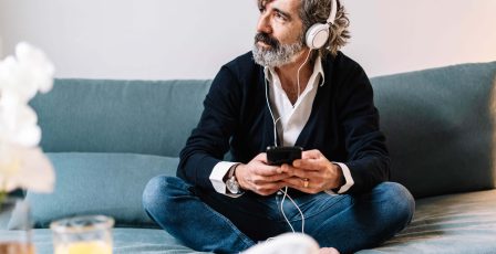 Man listening to smart phone with headphones