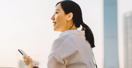 Young woman using her mobile phone outside