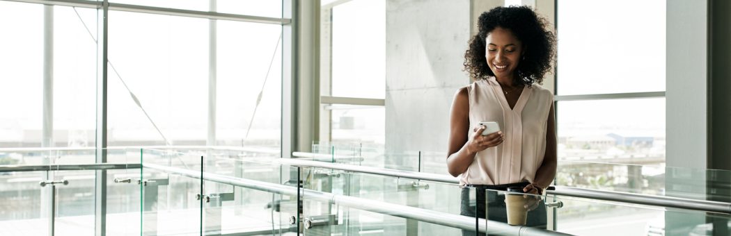 Young woman at work using her mobile phone