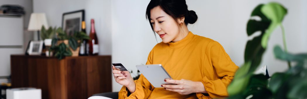 Young woman using her credit card online