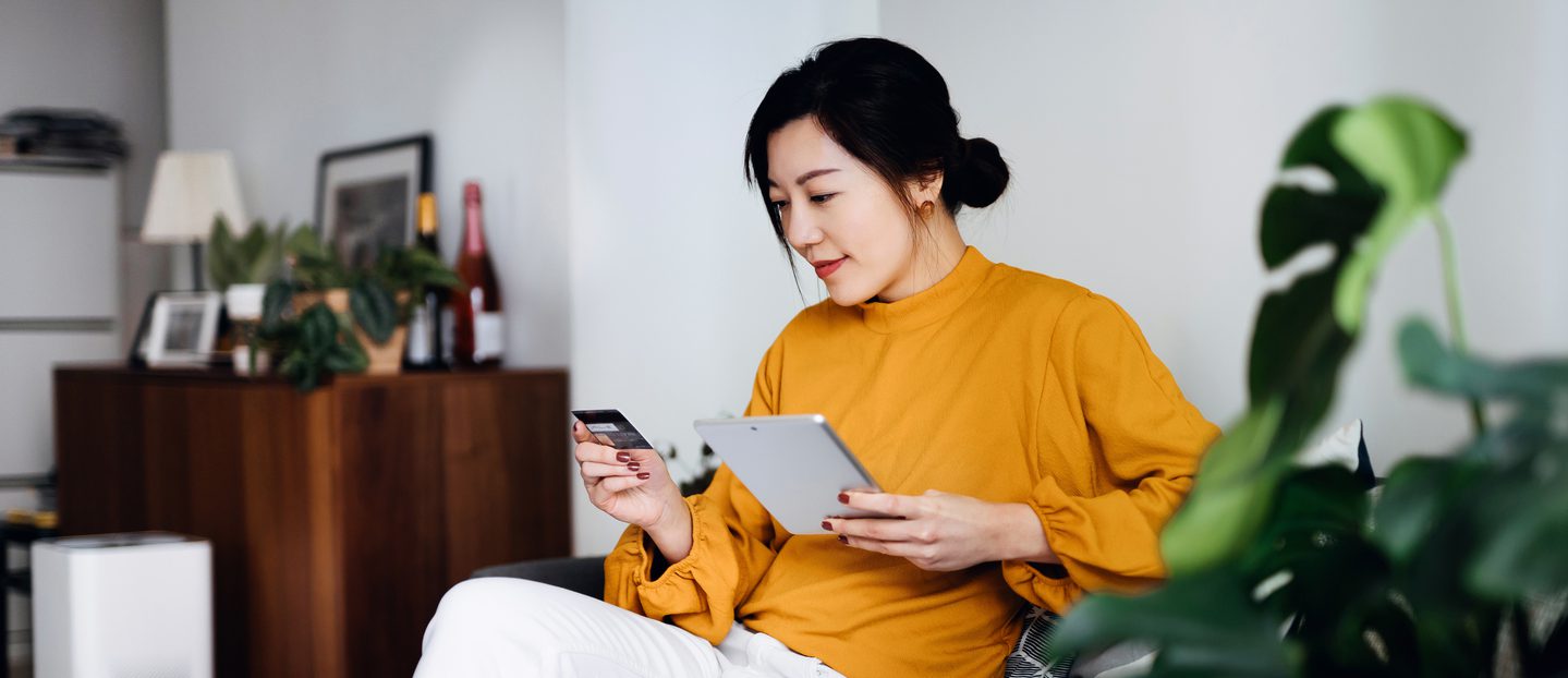 Young woman using her credit card online