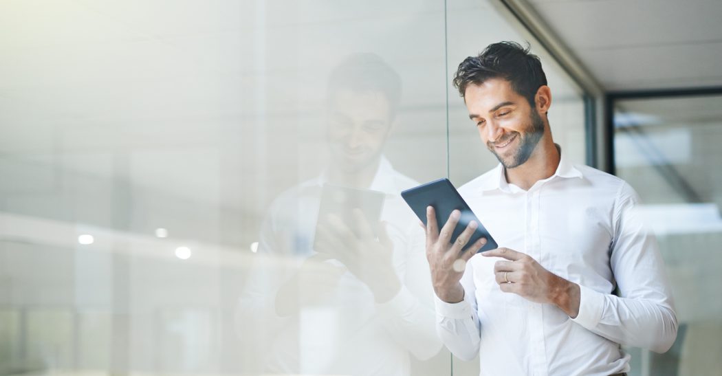 Man on a tablet stood by a window