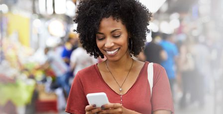 Woman smiling while looking at phone