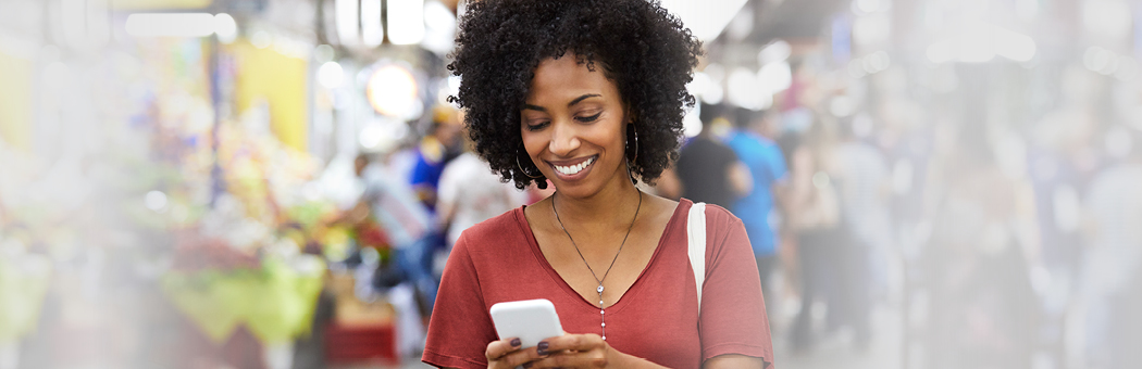 Woman smiling while looking at phone