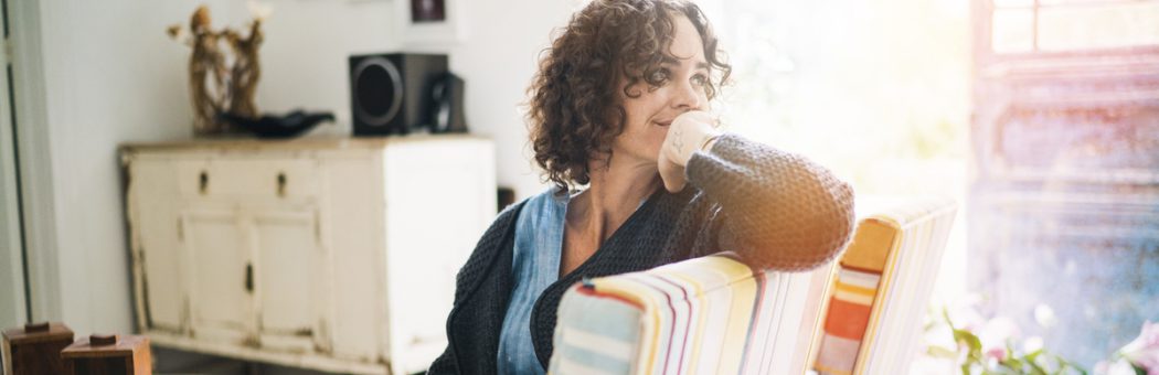 Thoughtful woman sitting on chair at home