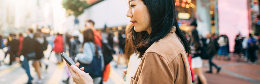 Young woman in a metropolitan city looking at her phone