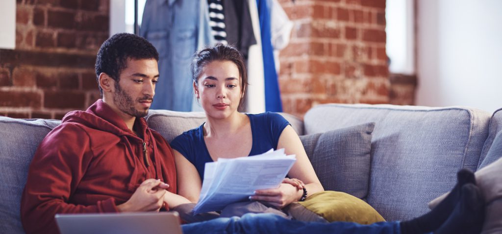 Couple sat at home looking at bills