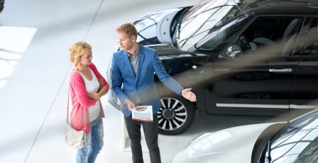 Woman being shown a car in a showroom