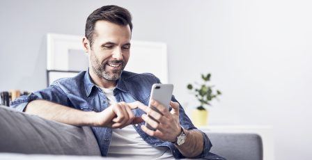 Man using a mobile phone on the sofa