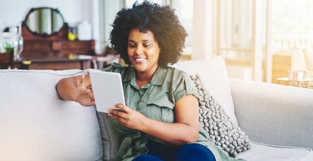 Woman browsing on a tablet in her living room