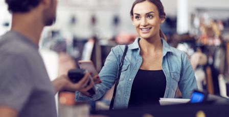 Woman paying for clothes with her mobile phone