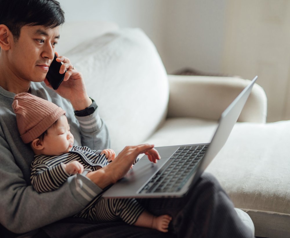 Man on the phone with a child on his lap